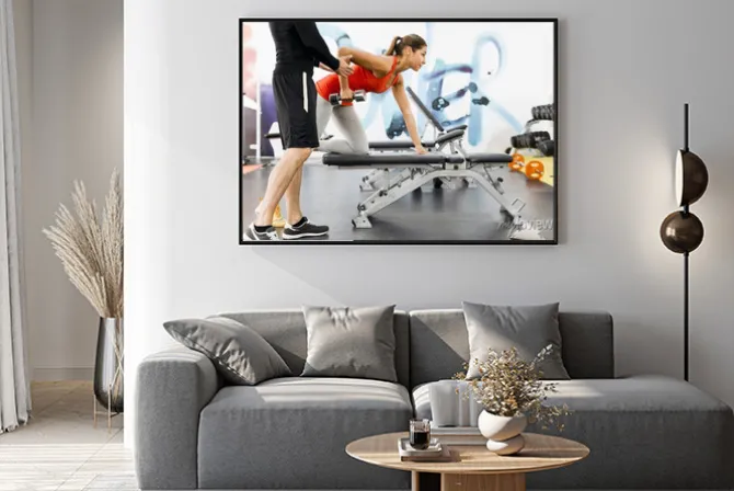 Plakat: Young male trainer giving instructions to a woman in a gym